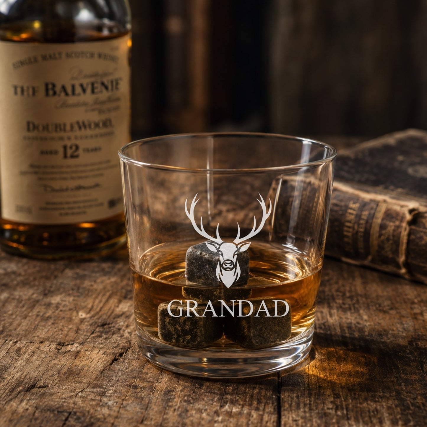 Glass of whiskey with 'Grandad' on a wooden surface next to a Balvenie bottle.