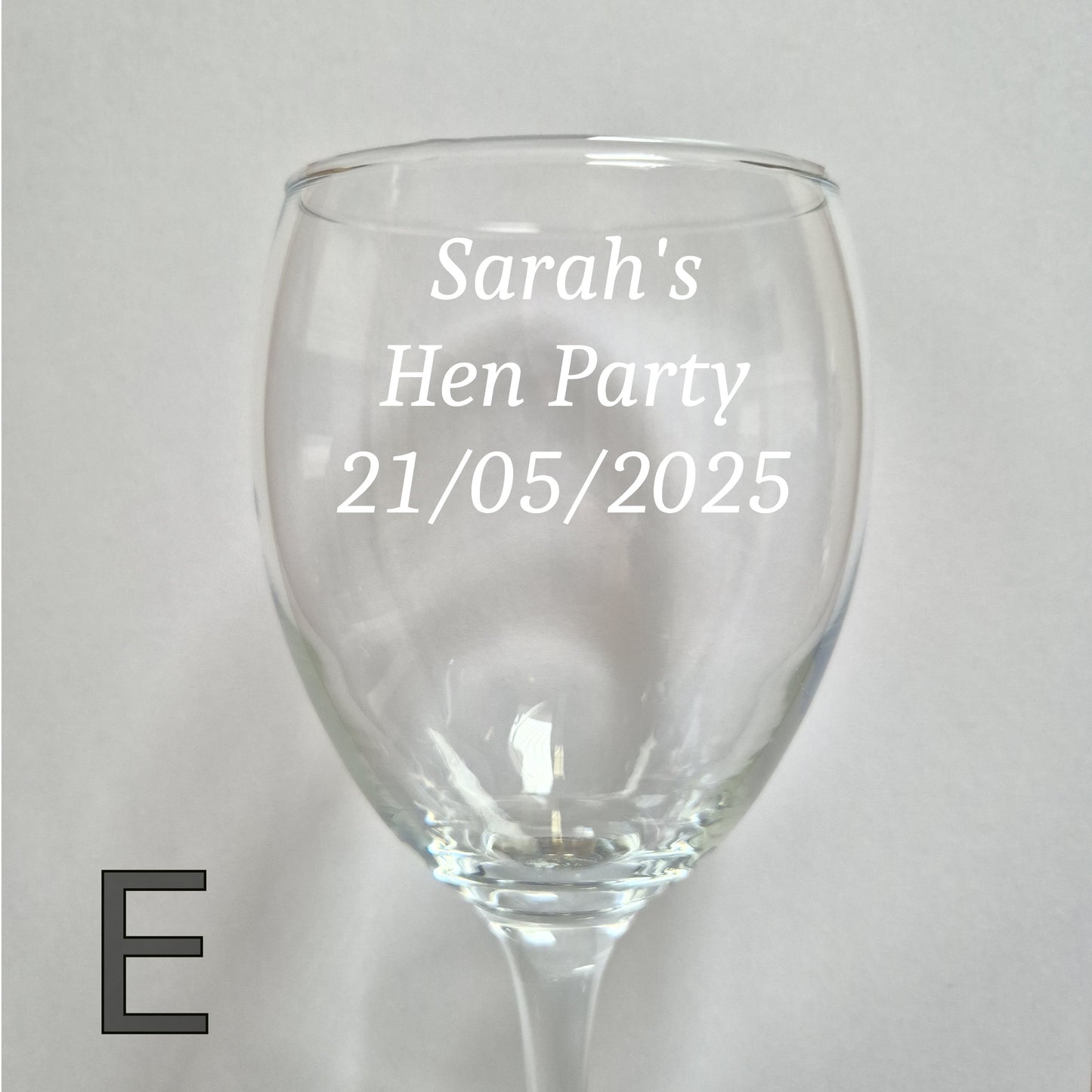 Personalised wine glass with 'Sarah's Hen Party 21/05/2025' text on a light gray background