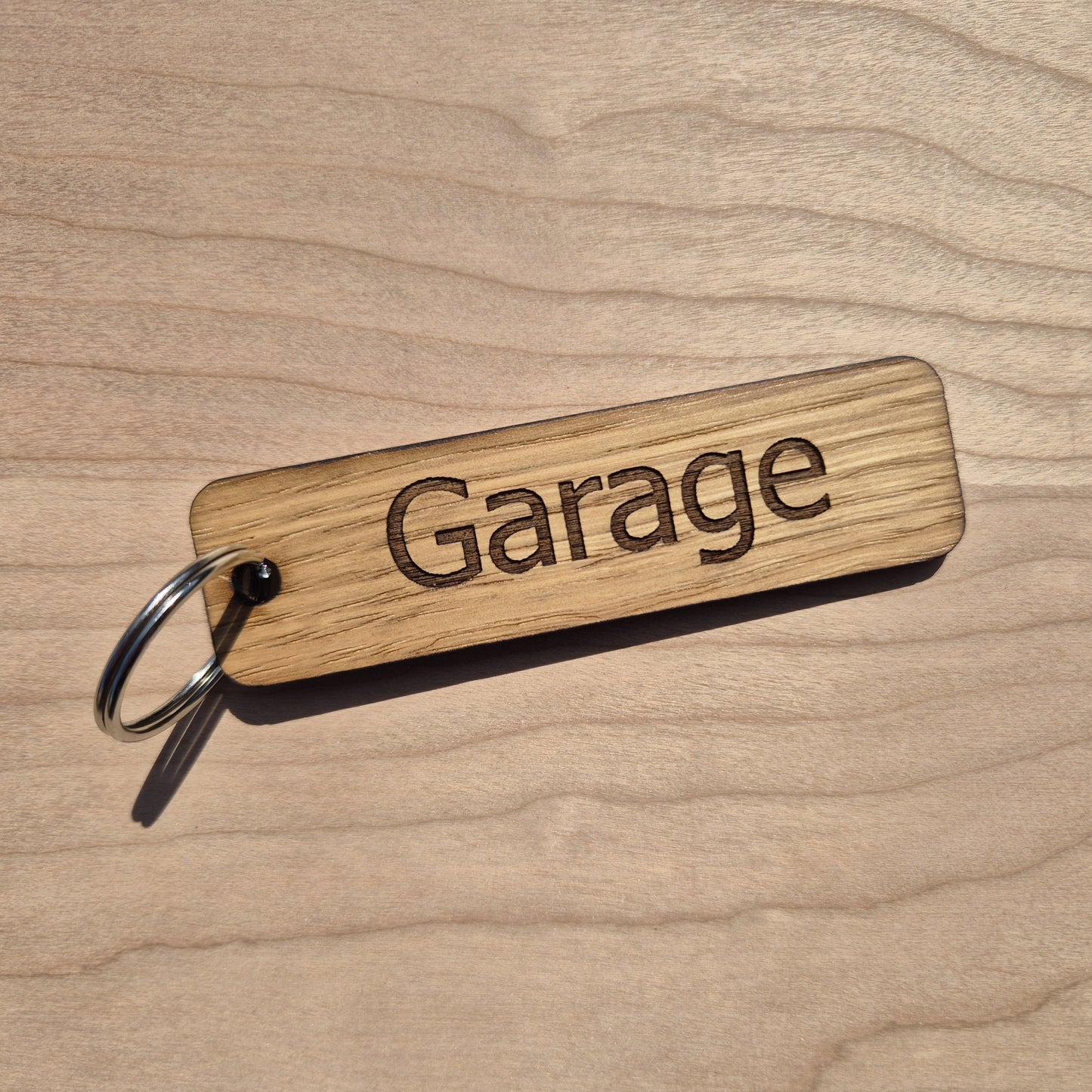 Oak keyrings measureing 90 x 25 x 4mm. Each keyring is engraved in a different font. This keyring says emmas garage.