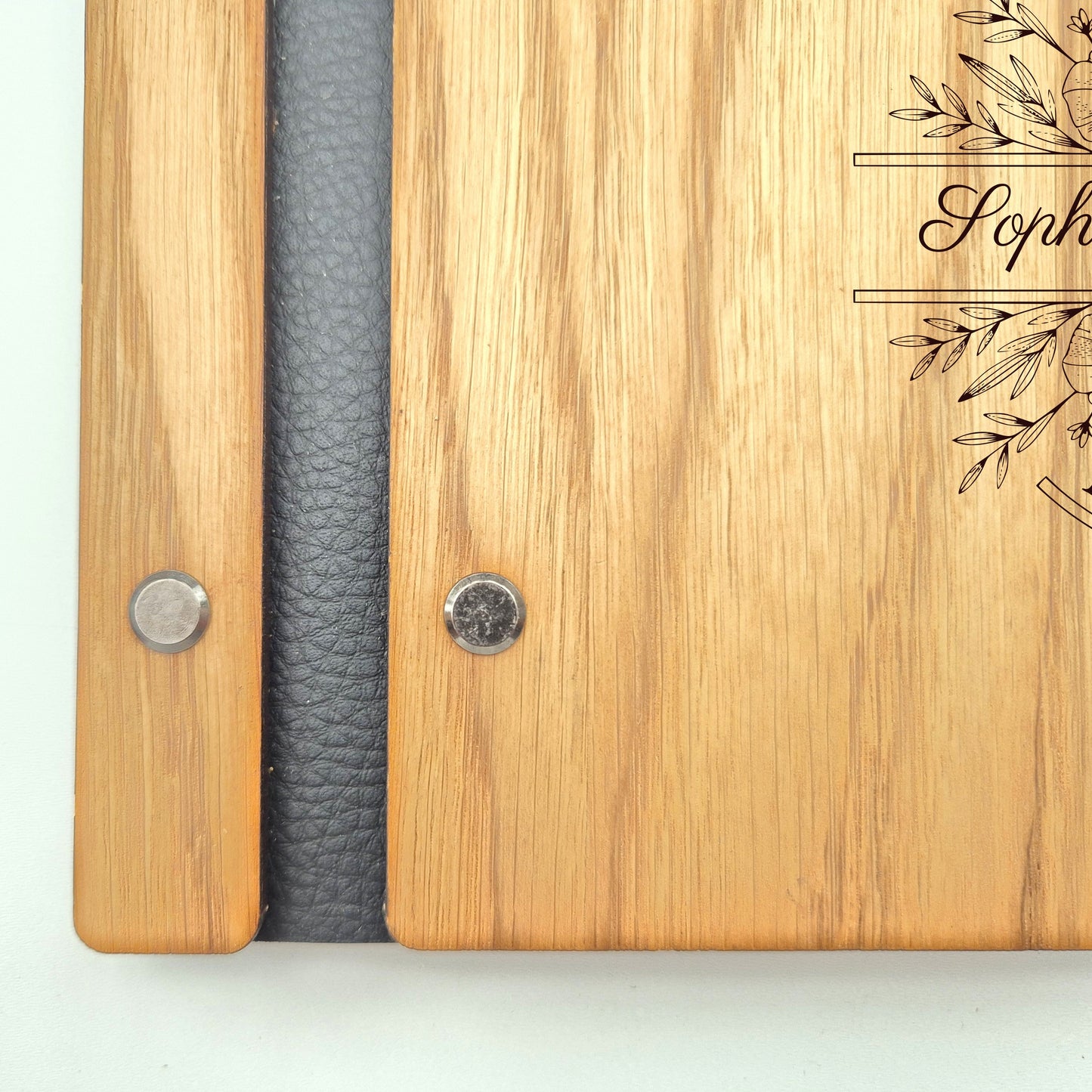 Image of a rustic style oak wedding book. The book is approximately 298mm x 216mm and includes high-quality paper. The oak wedding book is laser engraved by laserengraveuk with a floral circular design to the front. The design includes the married couple's names, date of wedding, and the venue.