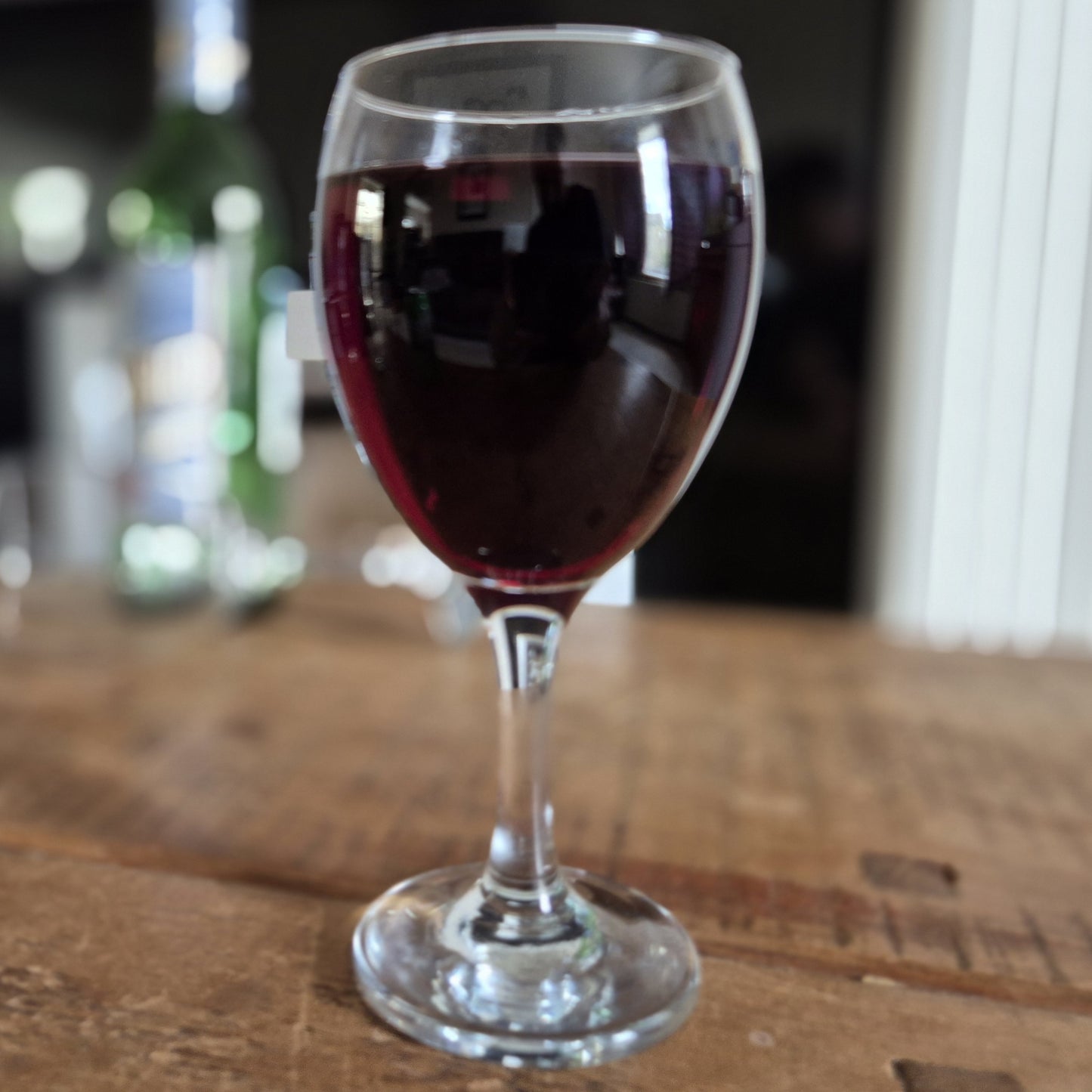 Wine glass filled with red wine on a wooden surface