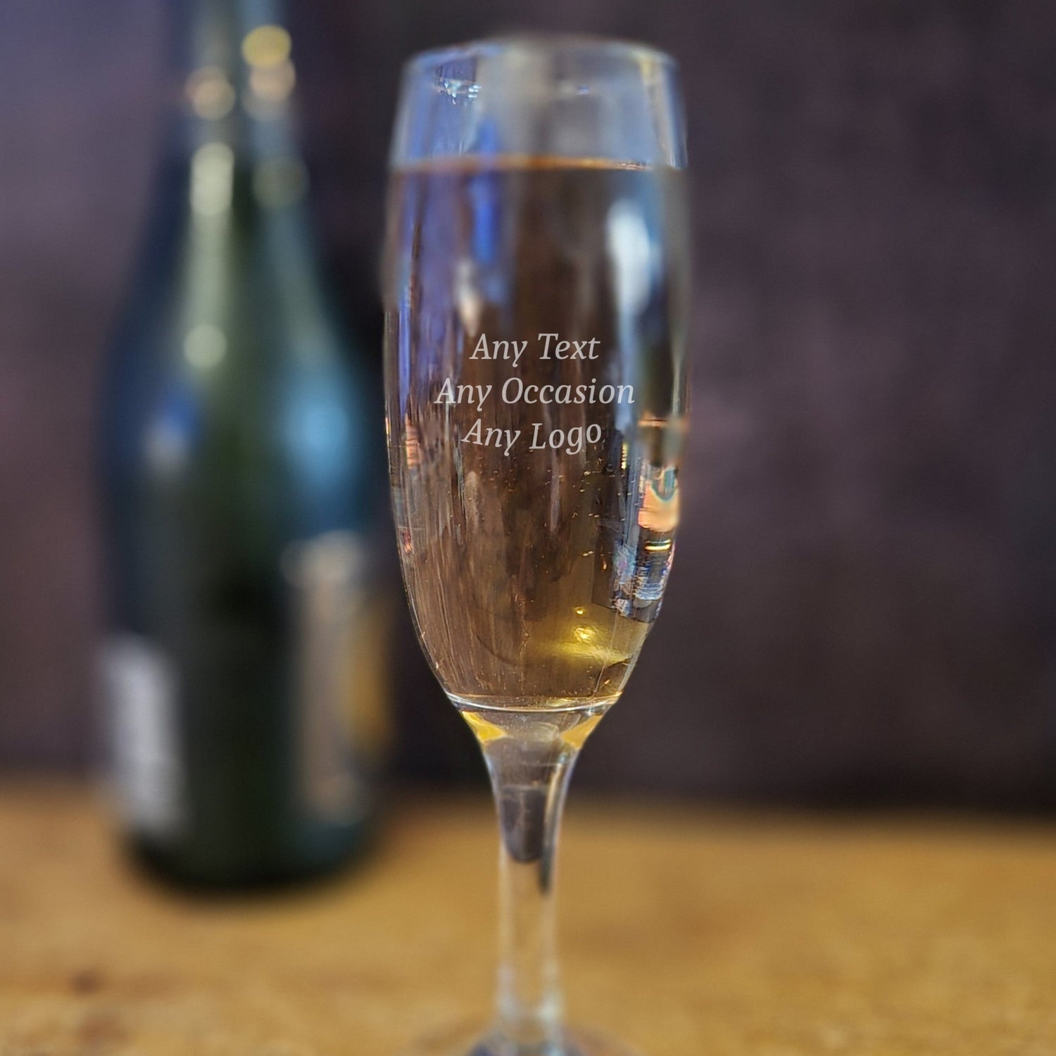 Personalised champagne glass on a wooden table.