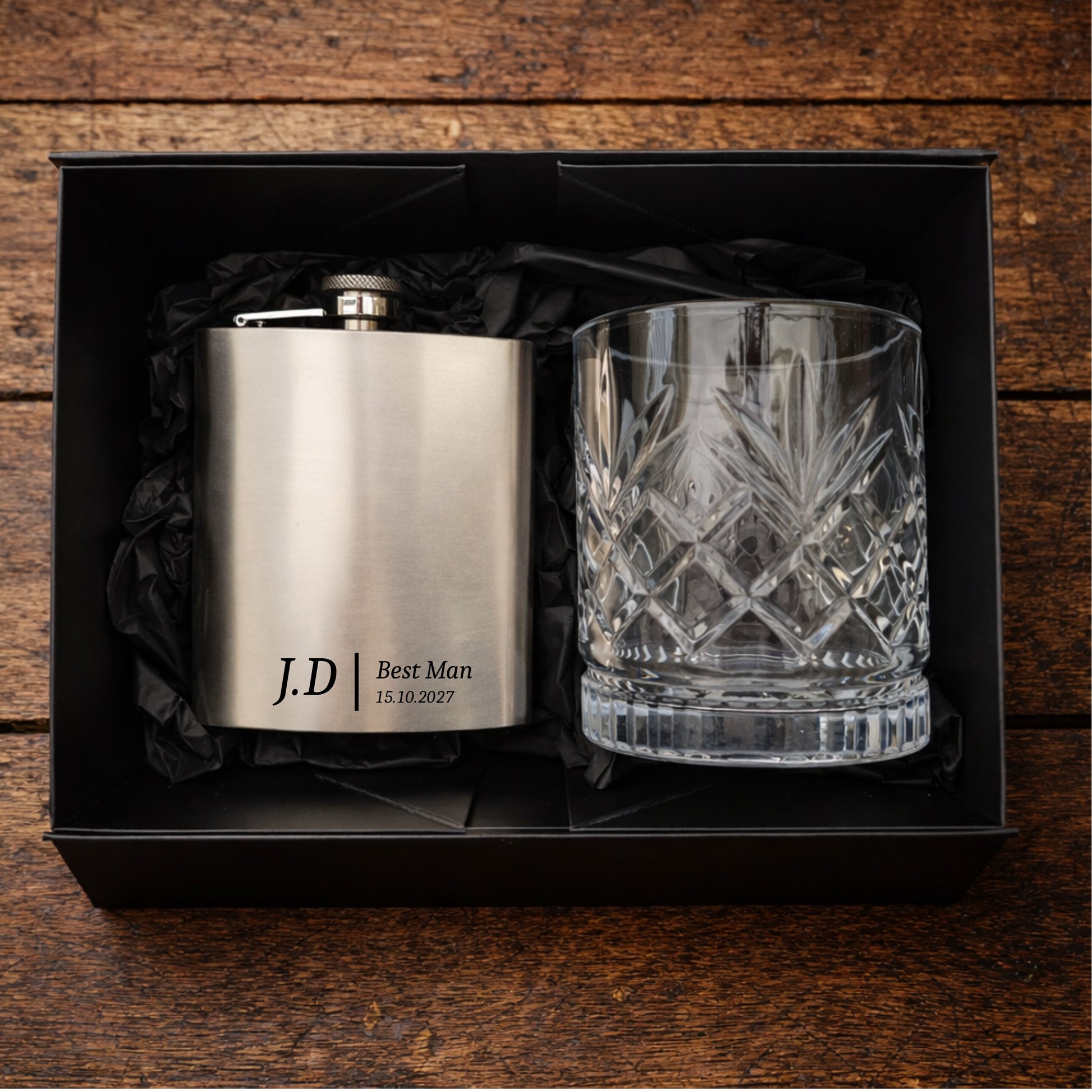 Personalised hip flask and glass set in a black box on a wooden surface