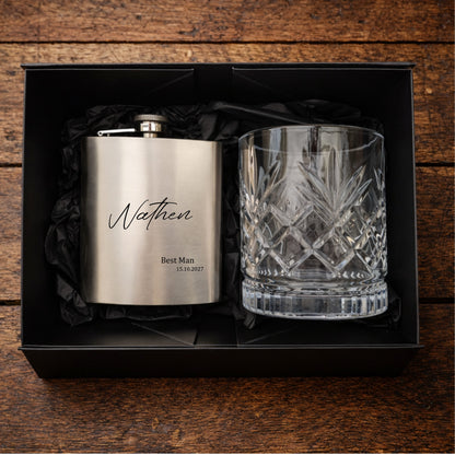 Stainless steel flask and crystal glass in a black box on a wooden surface