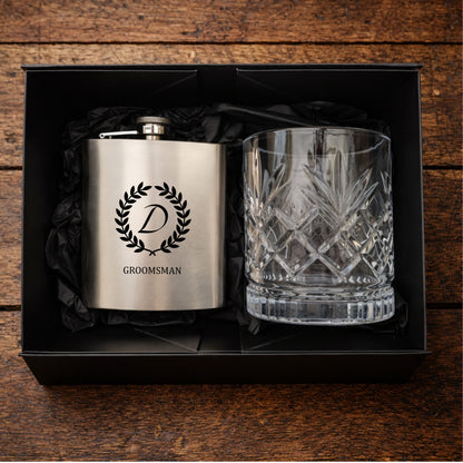 Silver flask and crystal glass in a black box on a wooden surface