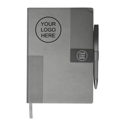 A gray hardcover notebook with a pen attached on the right side, featuring a ribbed texture and customizable black logo placeholders on the front cover and a small label near the pen clip.