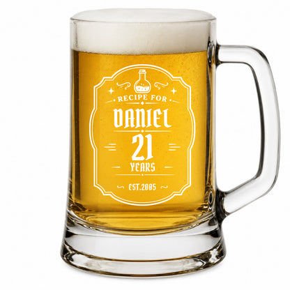 Glass mug filled with beer and personalized engraving on a white background