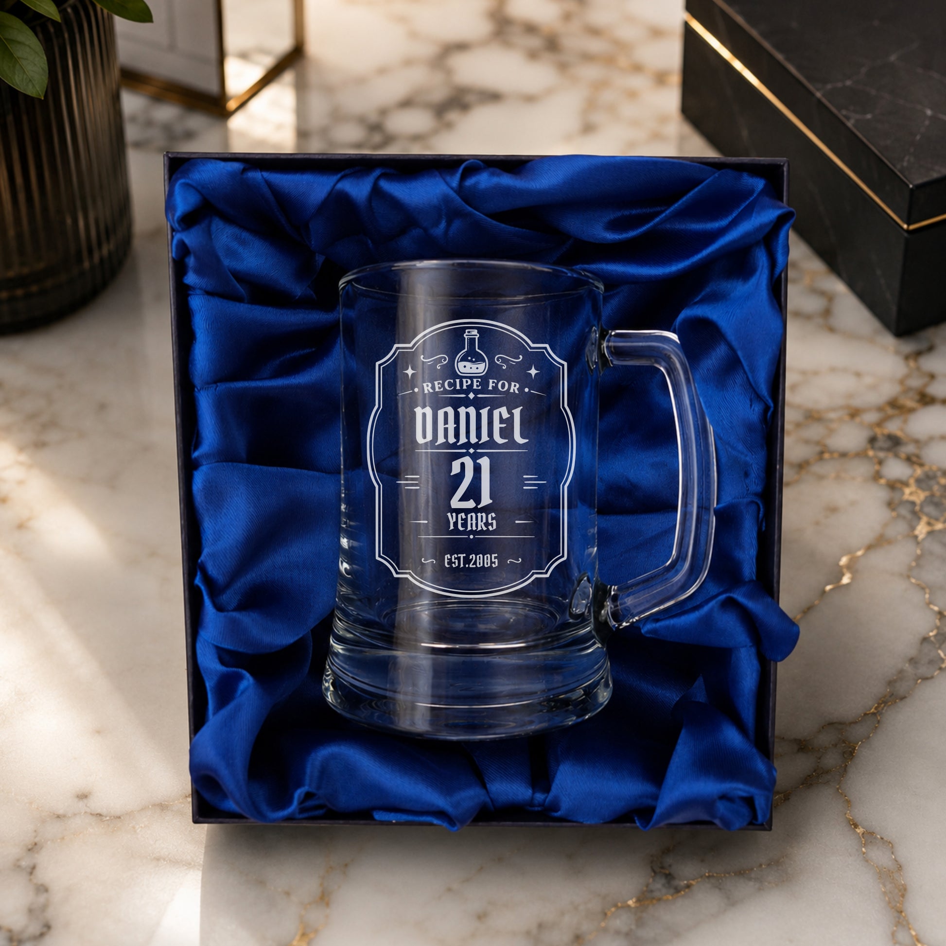 Personalized glass mug with engraved text in a decorative box on a marble surface