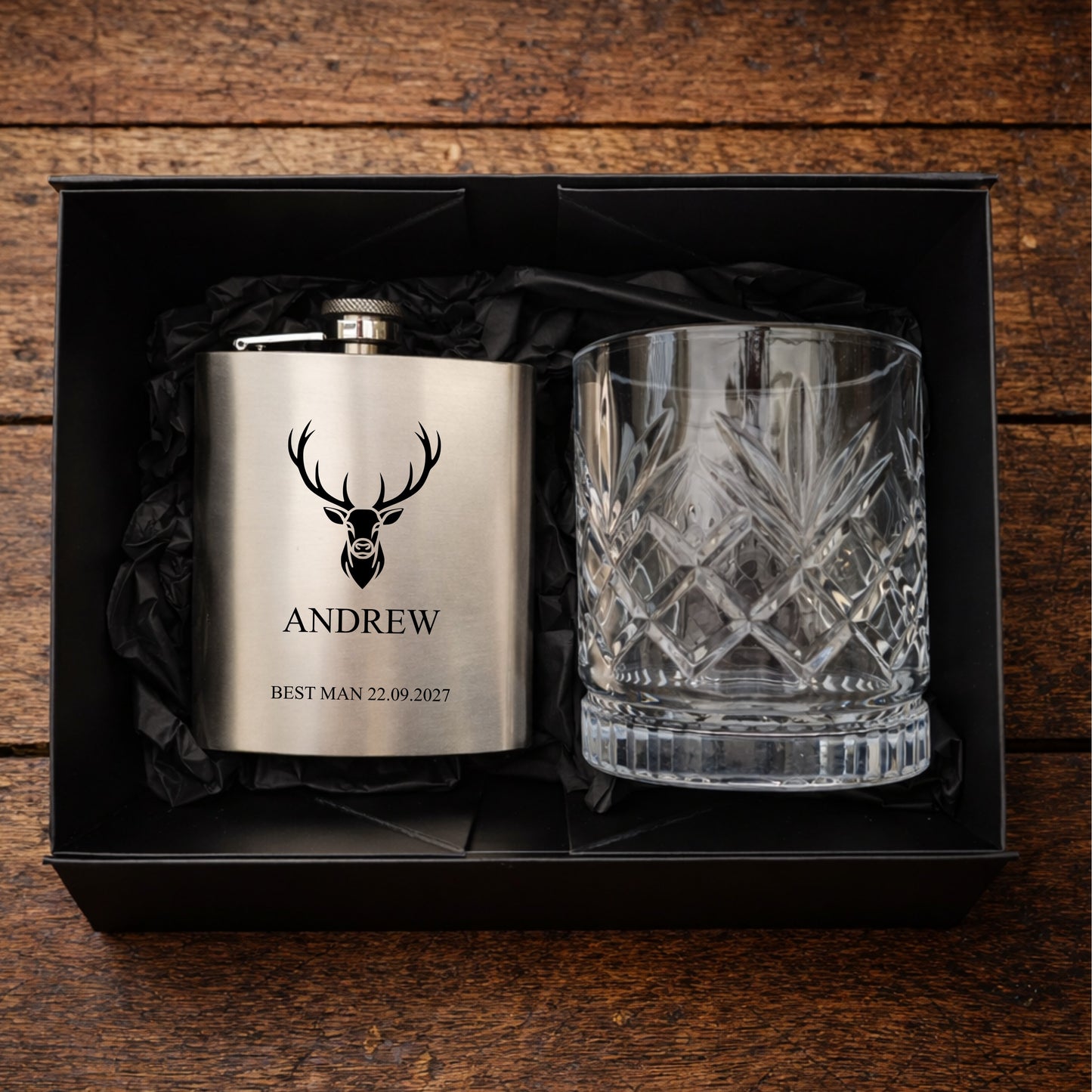 Personalized flask and glass set in a black box on a wooden background