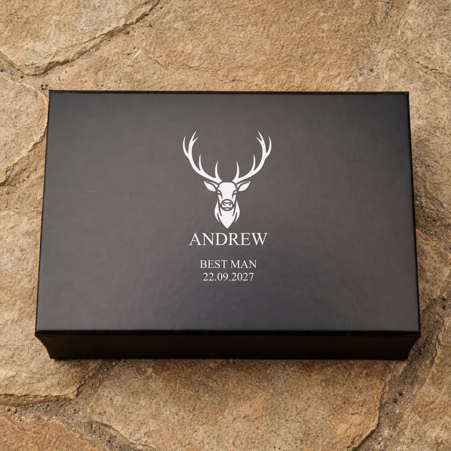 Black box with a deer logo and text on a stone surface
