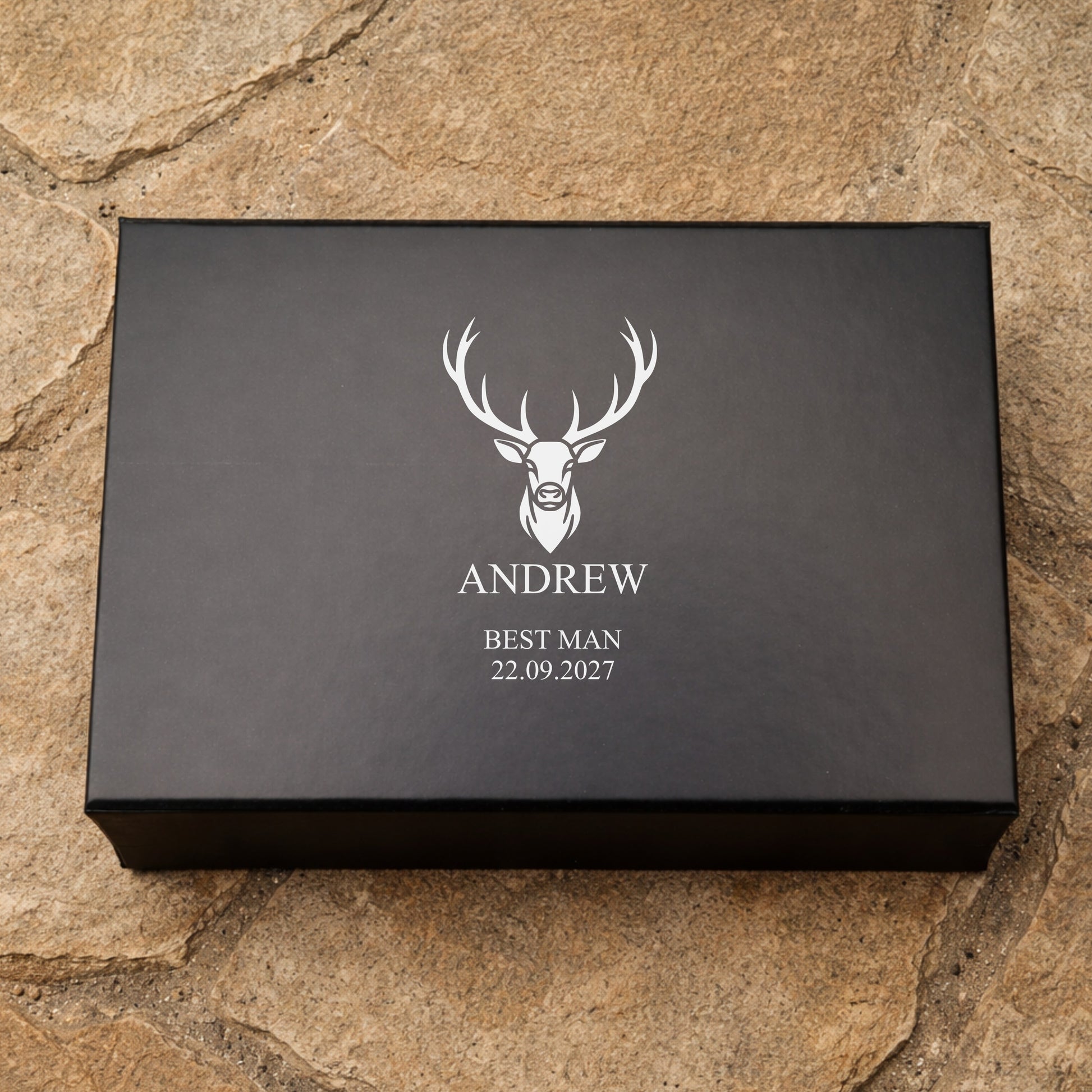 Black box with a deer logo and text on a stone surface