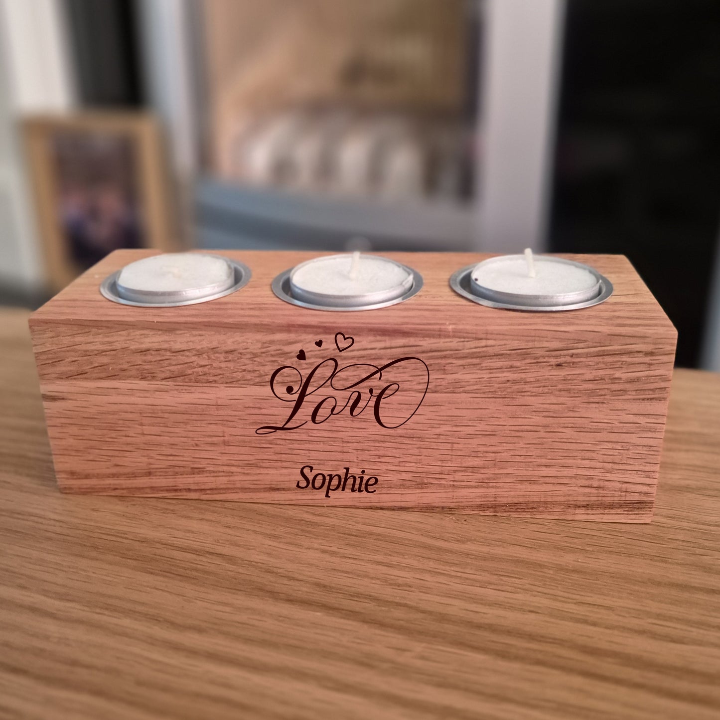 Oak tealight holder with 'Love Sophie' engraving on a wooden surface.