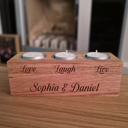 Oak candle holder with engraved text on a wooden surface