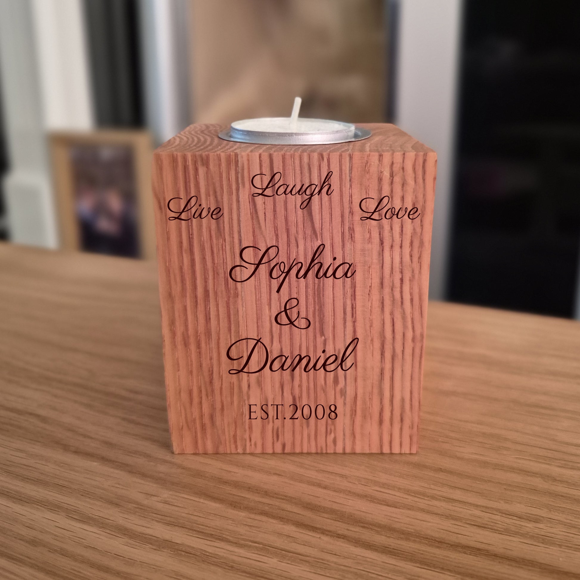 Oak tealight holder with engraved names on a wooden surface