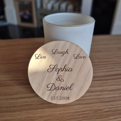 White jar candle with engraved wooden lid. 