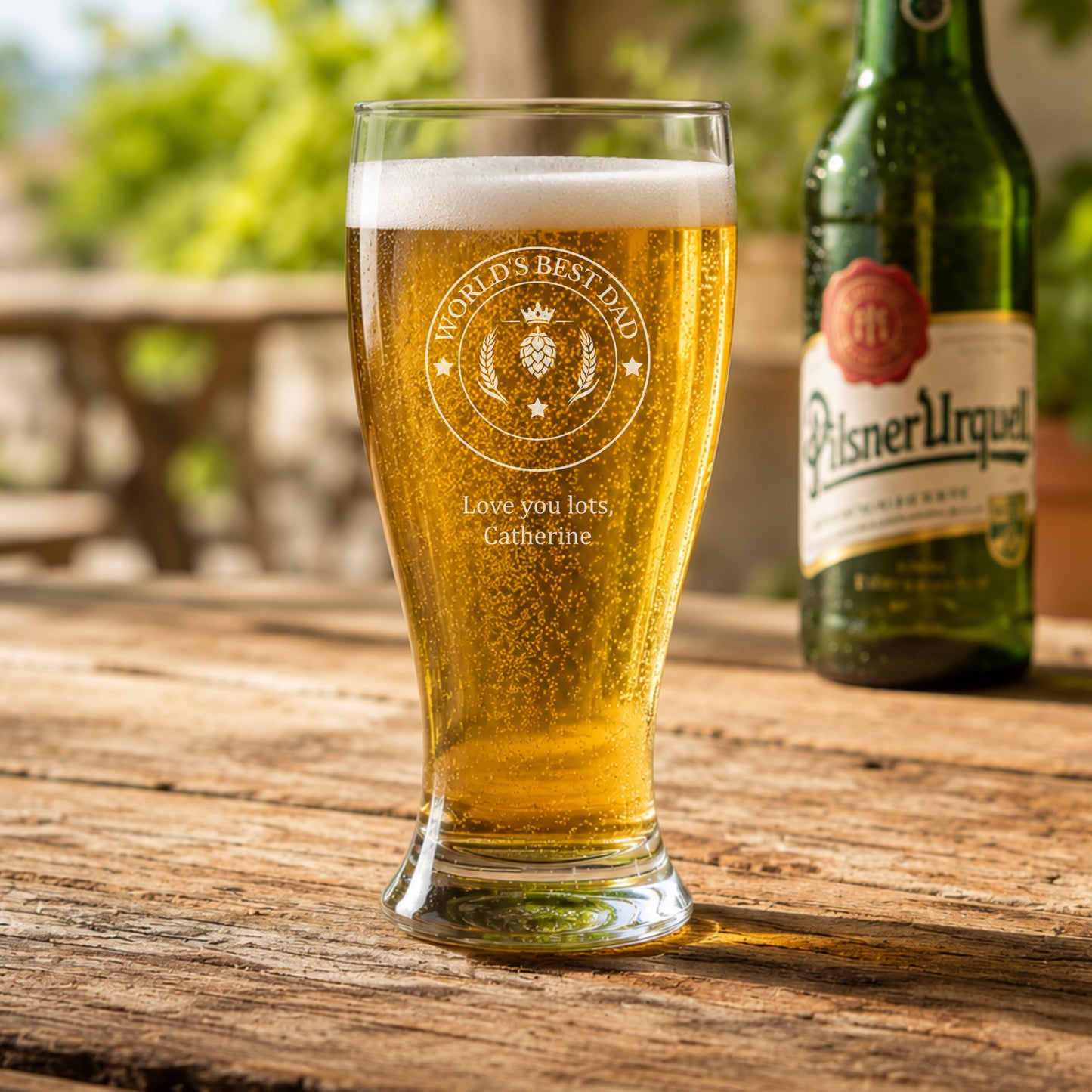 Personalised beer glass with fathers day engraving on a wooden table.