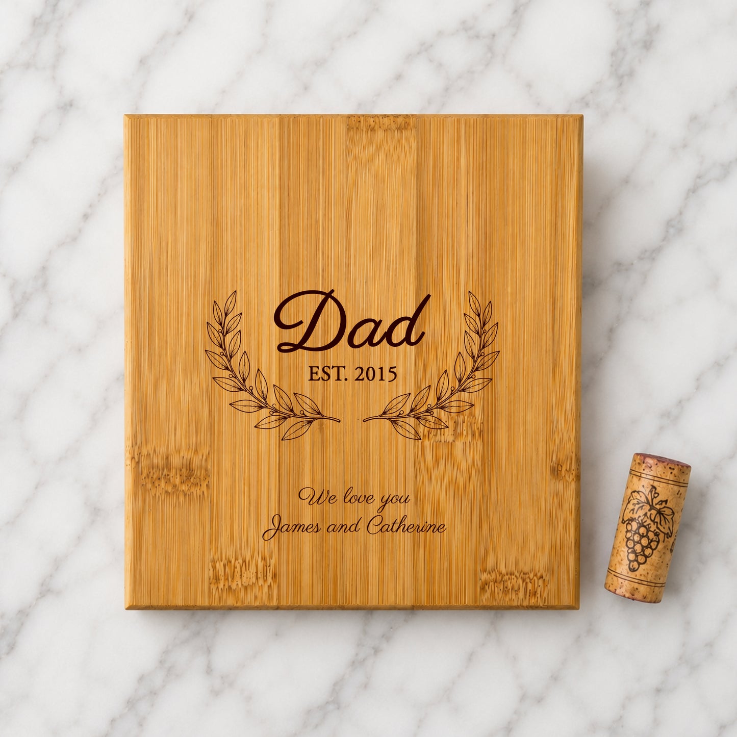 Wooden box engraved with 'Dad Est. 2015' and a cork on a marble background