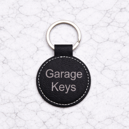 Black leather keychain with 'Garage Keys' text on a textured white background