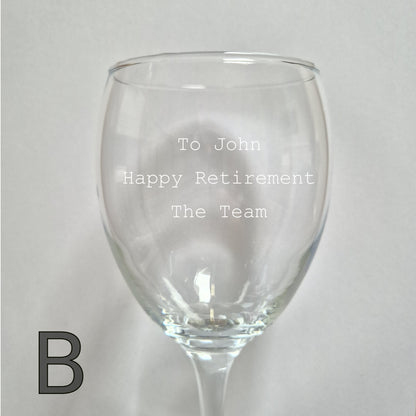 Personalised wine glass with engraved text on a light gray background