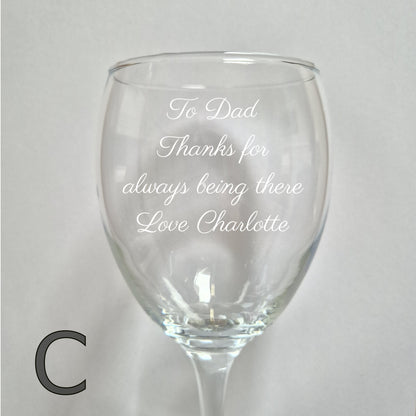 Personalised wine glass with engraved message on a light gray background
