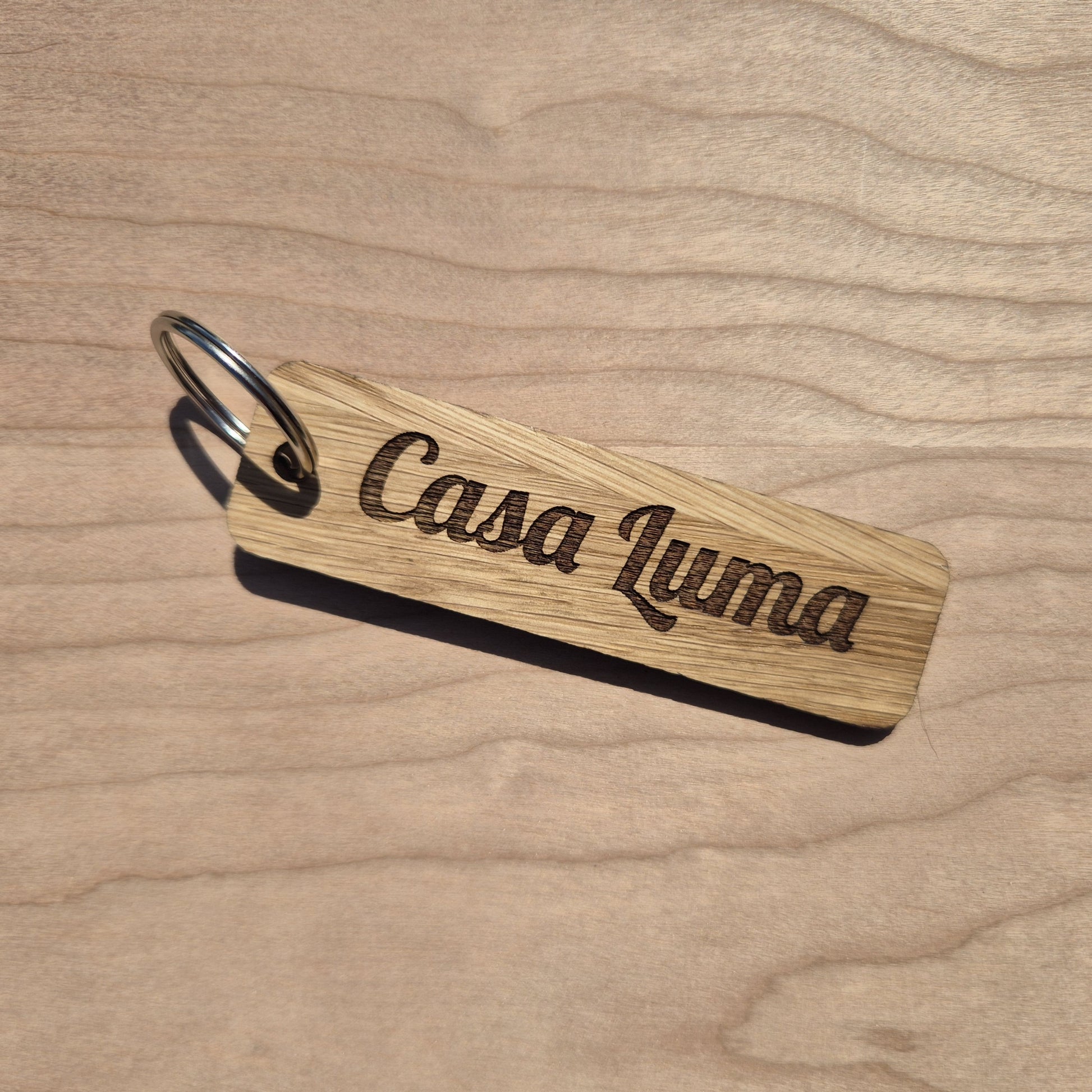 Oak keyrings measureing 90 x 25 x 4mm. Each keyring is engraved in a different font. This keyring says Casa Luma.