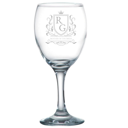 Clear wine glass with engraved crest and initials on a white background