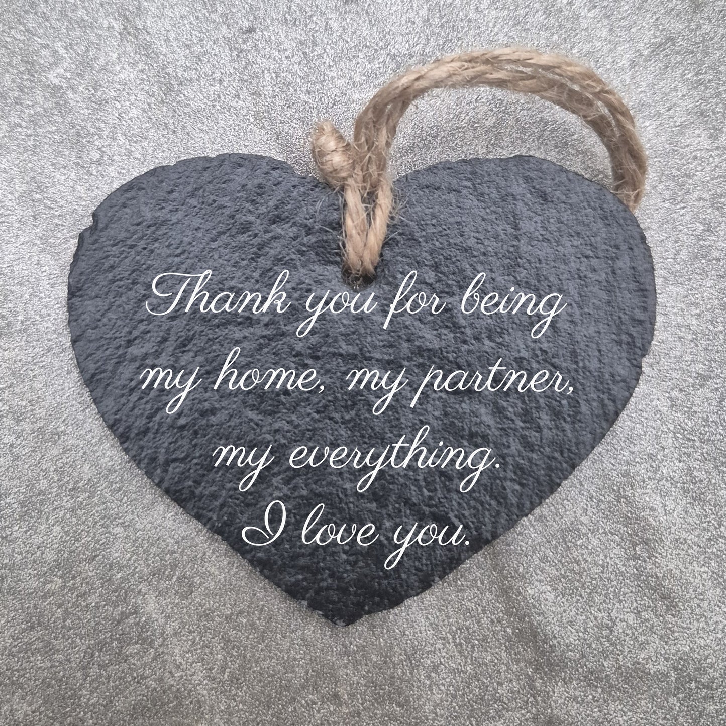 Heart-shaped slate plaque with a romantic message on a textured surface