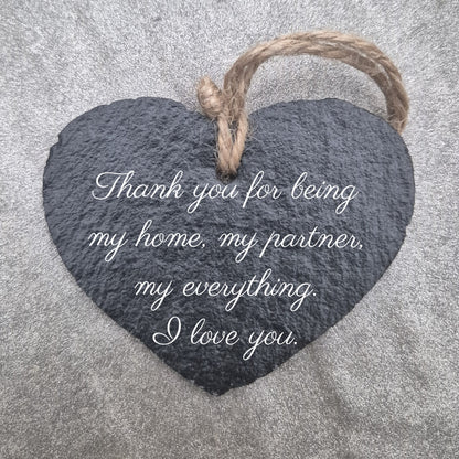 Heart-shaped slate plaque with a romantic message on a textured surface