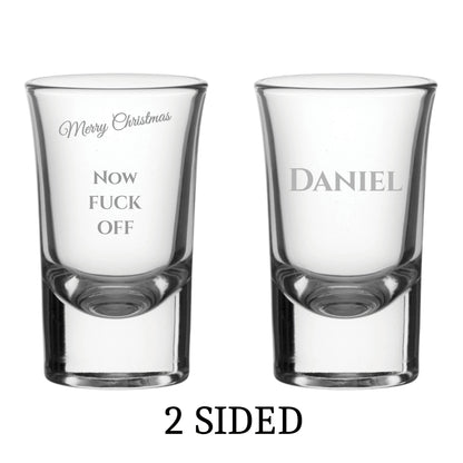 Two clear shot glasses with printed text on a white background