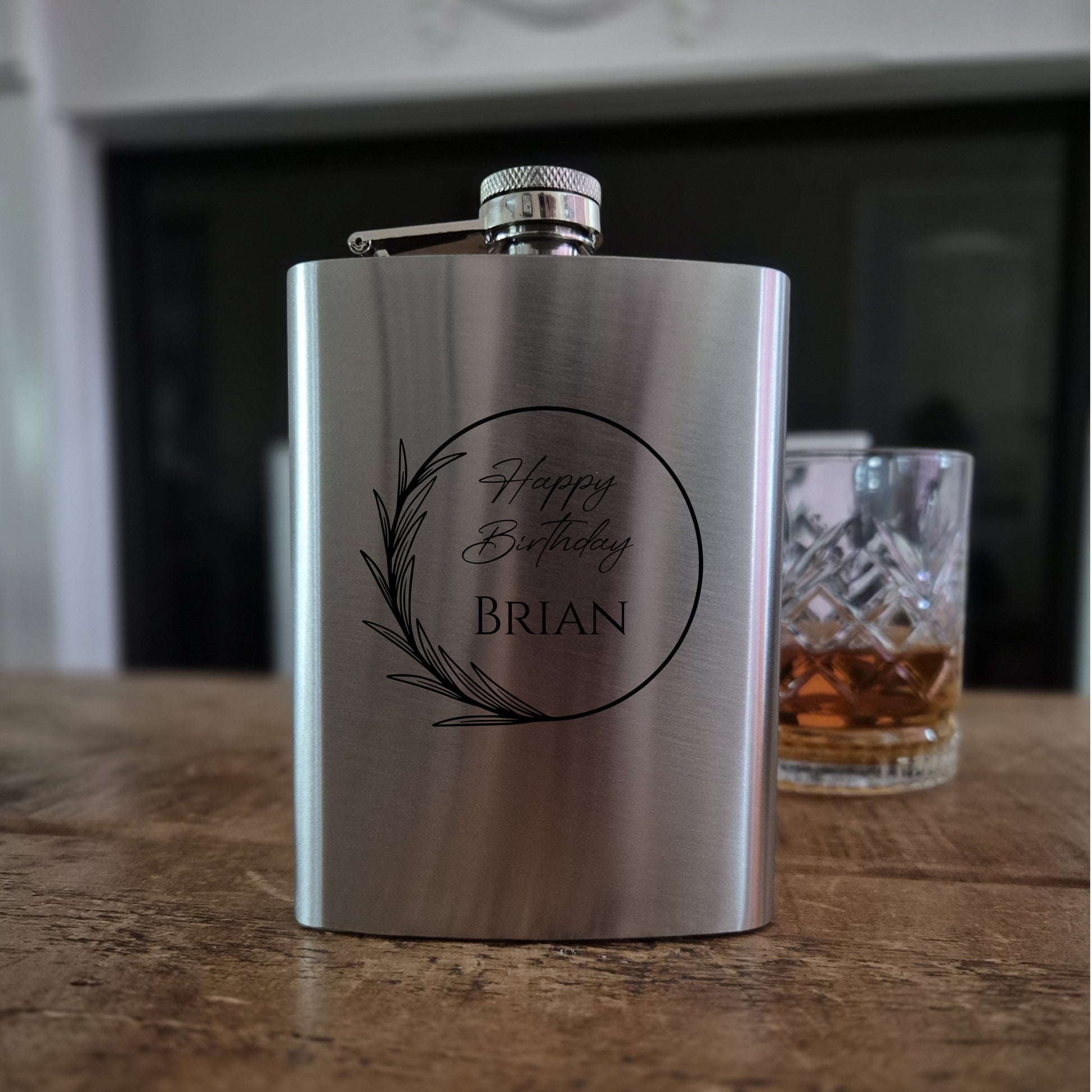 Stainless steel flask with 'Happy Birthday Brian' engraving on a wooden surface.