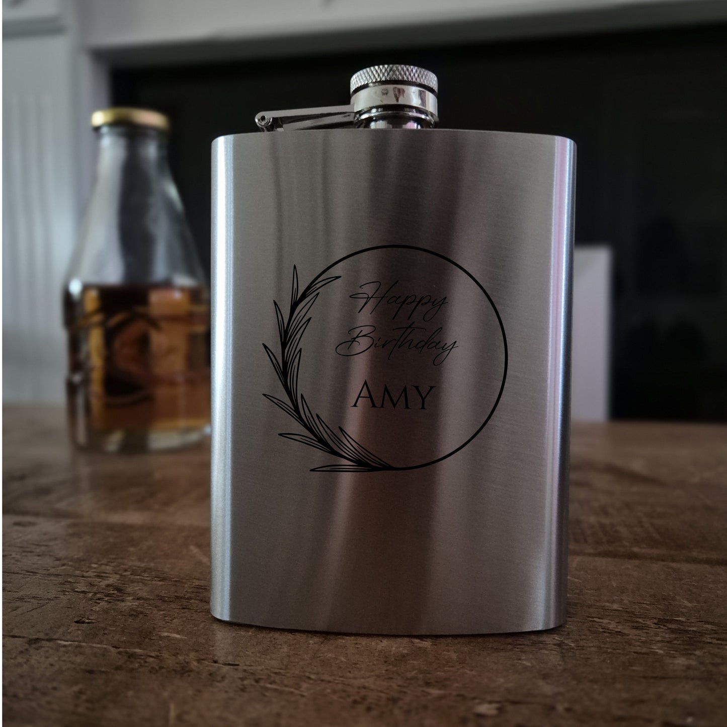 Stainless steel flask with 'Happy Birthday Amy' engraving on a wooden surface.