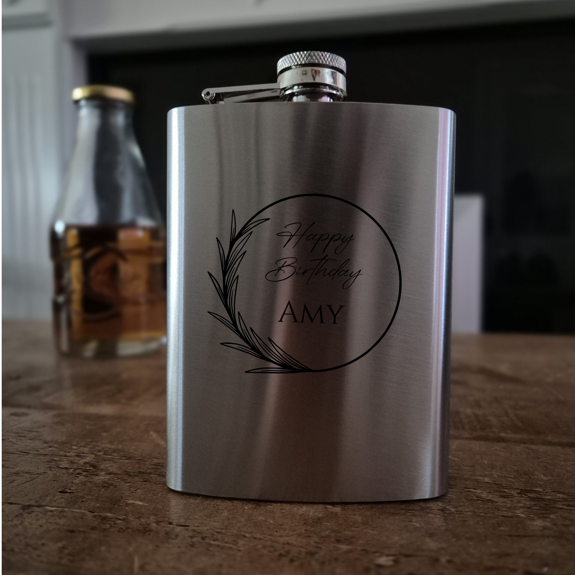 Stainless steel flask with 'Happy Birthday Amy' engraving on a wooden surface.