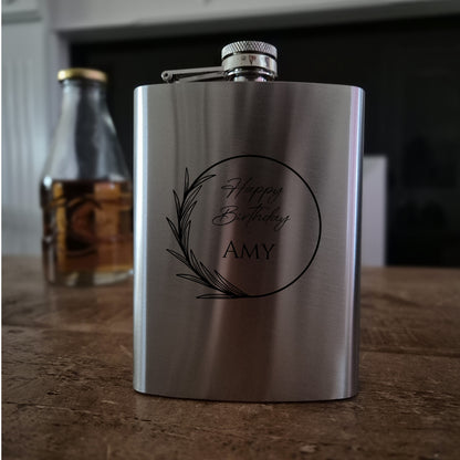 Stainless steel flask with 'Happy Birthday Amy' engraving on a wooden surface.