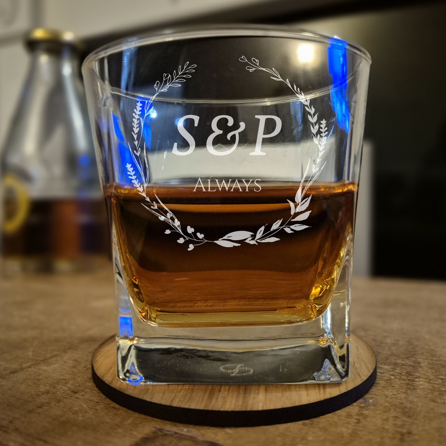 Glass with 'S&P Always' engraving on a wooden coaster