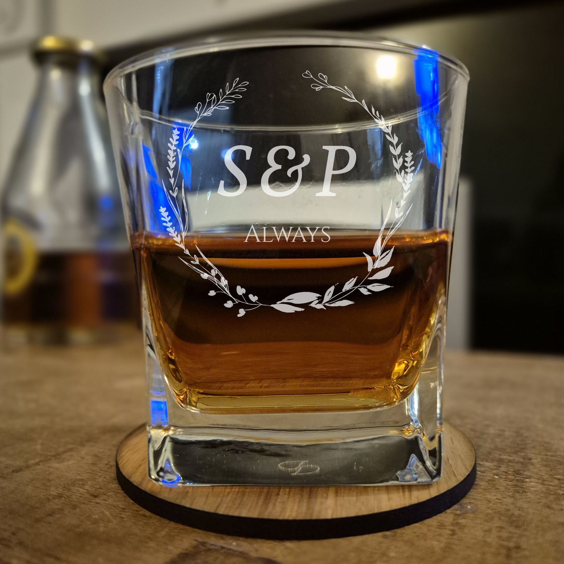 Glass with 'S&P Always' engraving on a wooden coaster