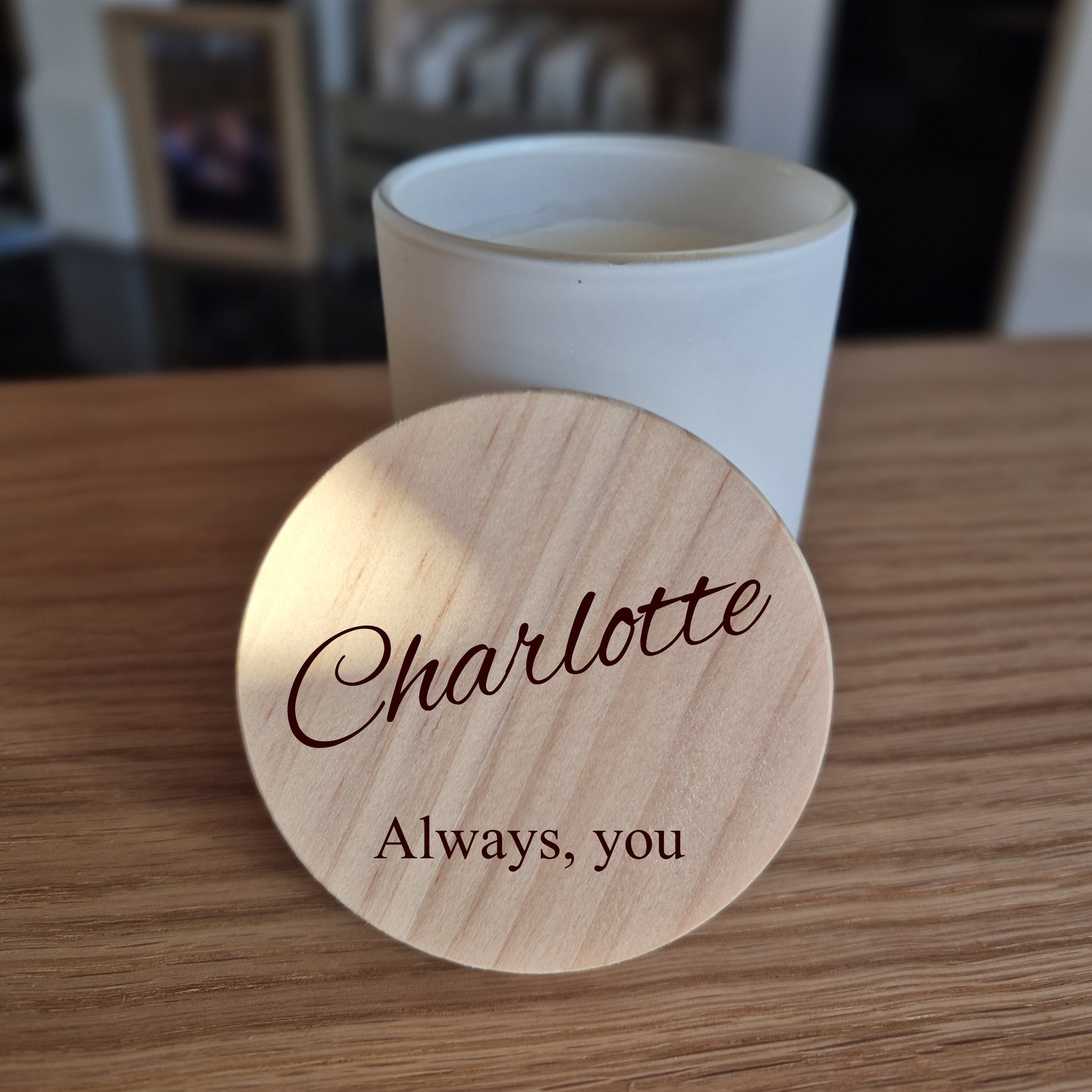 Personalised soy candle with wooden engraved lid. 'Charlotte Always, you' engraved on a wooden lid with a blurred background