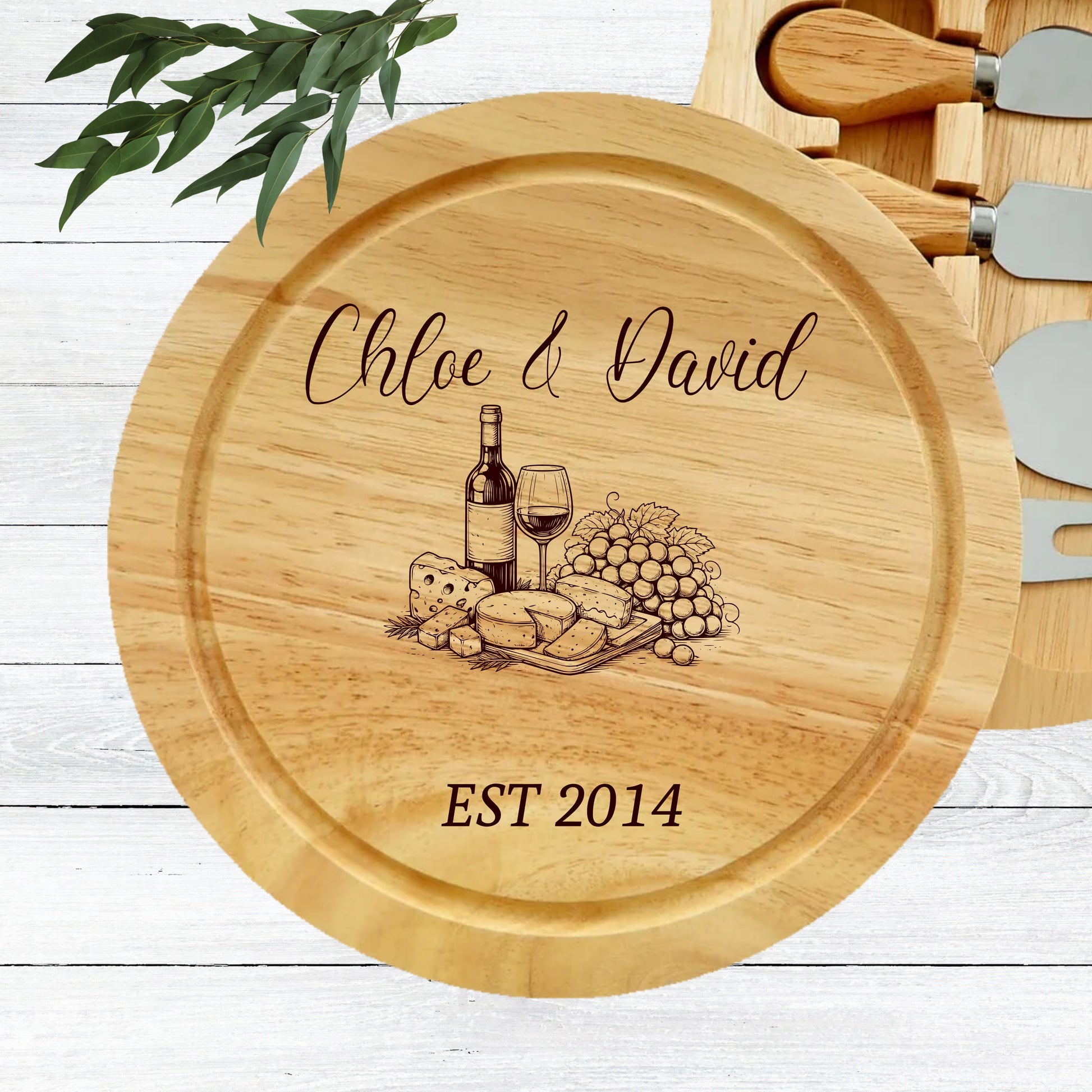 Wooden cheese board with engraved design of a bottle of wine, glass, and food, along with 'Chloe & David EST 2014' text.