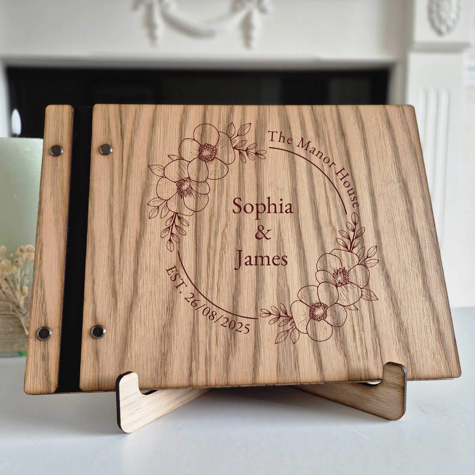 Image of a rustic style oak wedding book. The book is approximately 298mm x 216mm and includes high quality paper. The oak wedding book is laser engraved by laserengraveuk.com with a floral circular design to the front. The dsign includes the married couples names, date of wedding and the venue.