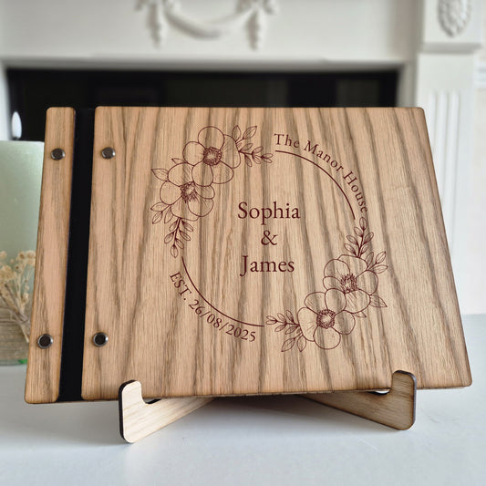 Image of a rustic style oak wedding book. The book is approximately 298mm x 216mm and includes high quality paper. The oak wedding book is laser engraved by laserengraveuk.com with a floral circular design to the front. The dsign includes the married couples names, date of wedding and the venue.