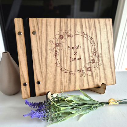 Image of a rustic style oak wedding book. The book is approximately 298mm x 216mm and includes high quality paper. The oak wedding book is laser engraved by laserengraveuk.com with a floral circular design to the front. The dsign includes the married couples names, date of wedding and the venue.