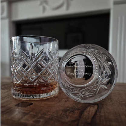 Two engraved whisky glasses. One on its side showing personalised engraving on the base