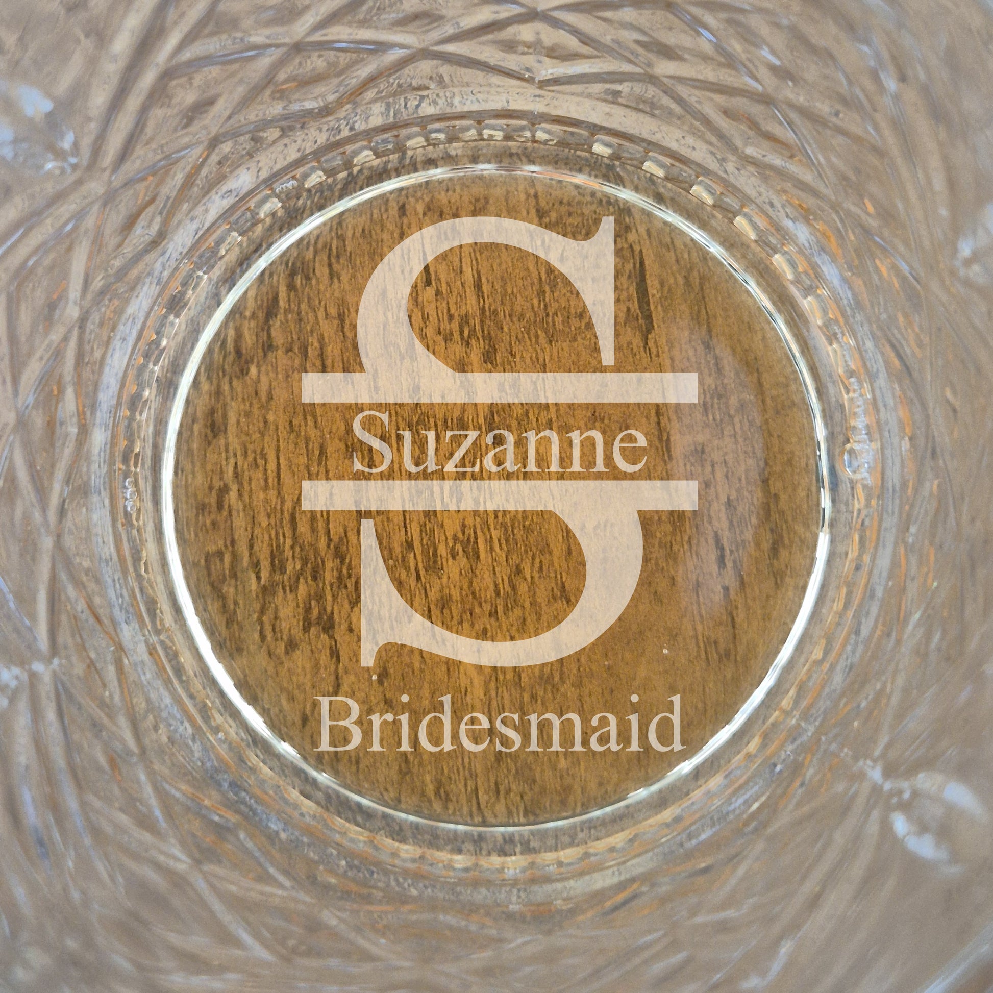 Personalized glass with engraved name and title on a wooden background