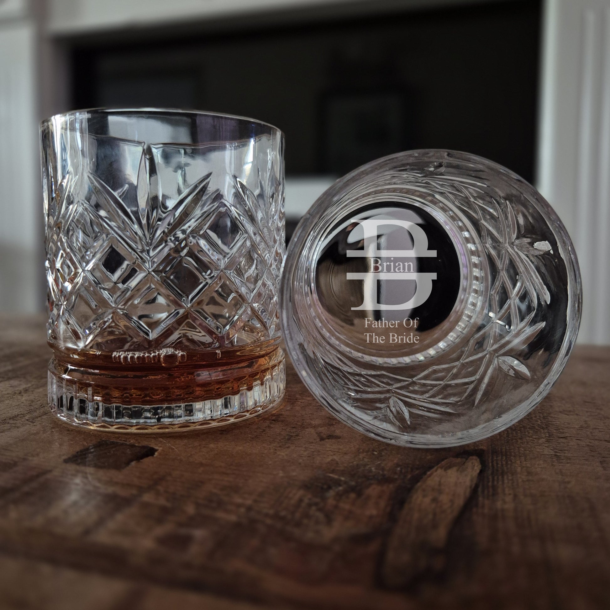 cut glass whisky glass on a table. The base has father of the bride and the fathers initial B engraved in the base.