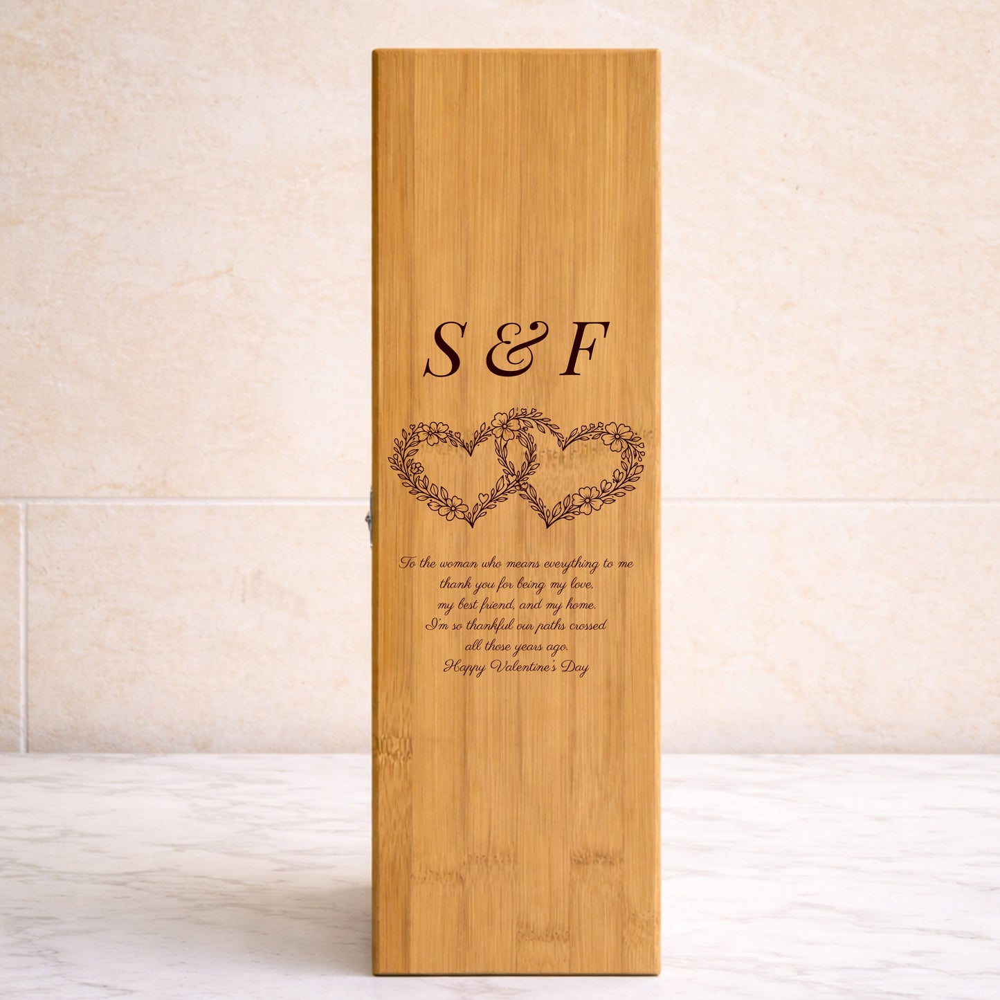 Wooden wine box with engraved hearts and text on a beige background