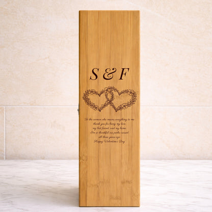 Wooden wine box with engraved hearts and text on a beige background