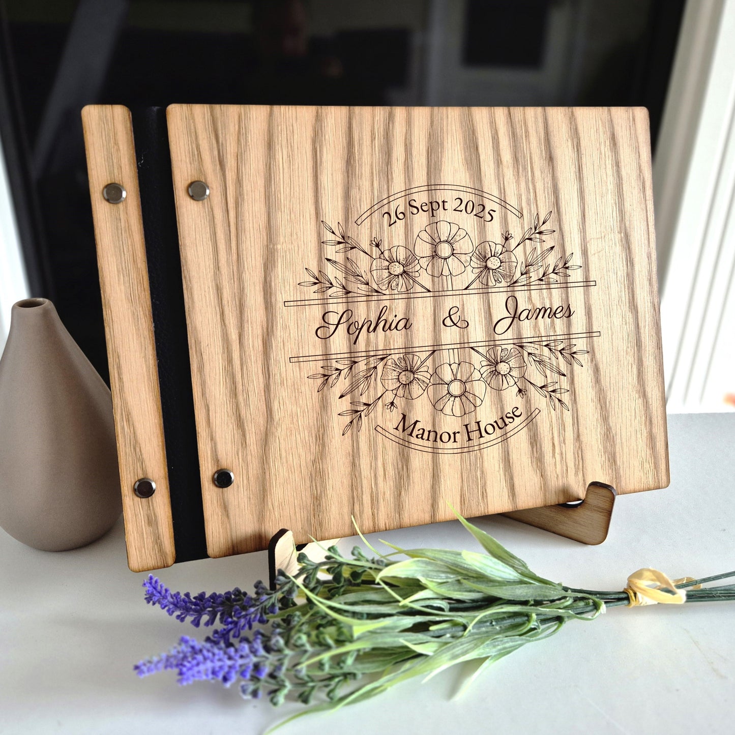 Image of a rustic style oak wedding book. The book is approximately 298mm x 216mm and includes high quality paper. The oak wedding book is laser engraved by laserengraveuk with a floral circular design to the front. The dsign includes the married couples names, date of wedding and the venue.