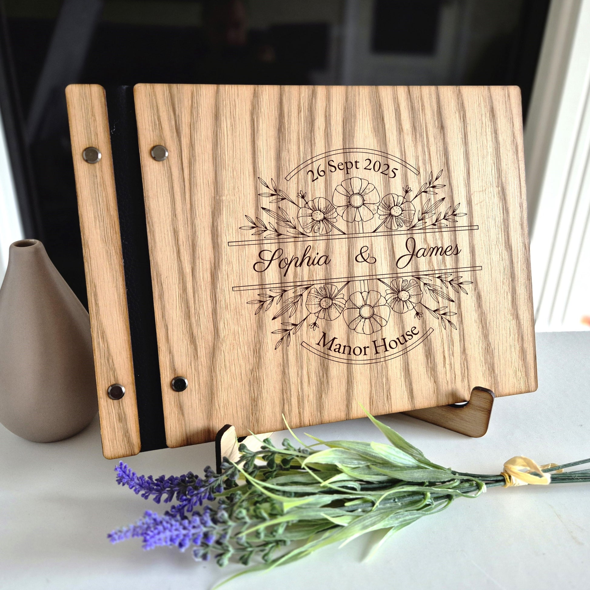 Image of a rustic style oak wedding book. The book is approximately 298mm x 216mm and includes high quality paper. The oak wedding book is laser engraved by laserengraveuk with a floral circular design to the front. The dsign includes the married couples names, date of wedding and the venue.