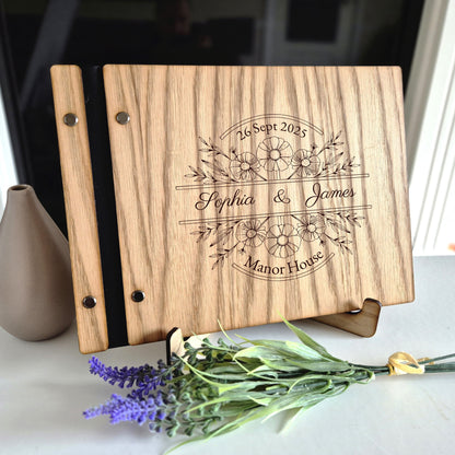 Image of a rustic style oak wedding book. The book is approximately 298mm x 216mm and includes high quality paper. The oak wedding book is laser engraved by laserengraveuk with a floral circular design to the front. The dsign includes the married couples names, date of wedding and the venue.