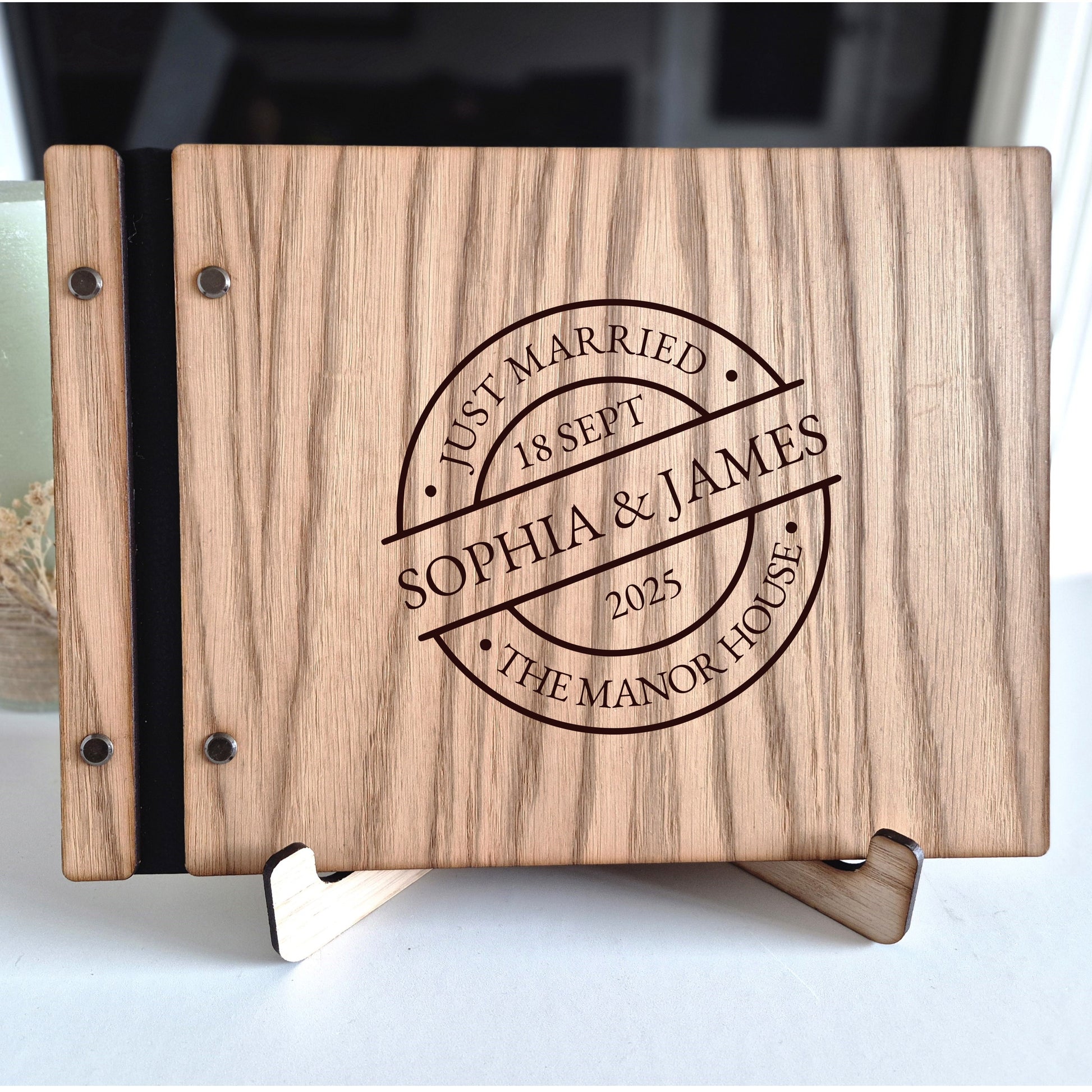 Image of a rustic style oak wedding book. The book is approximately 298mm x 216mm and includes high quality paper. The oak wedding book is laser engraved by laserengraveuk with a circular just married stamp design to the front. The design includes the married couple's names, date of wedding, and the venue.