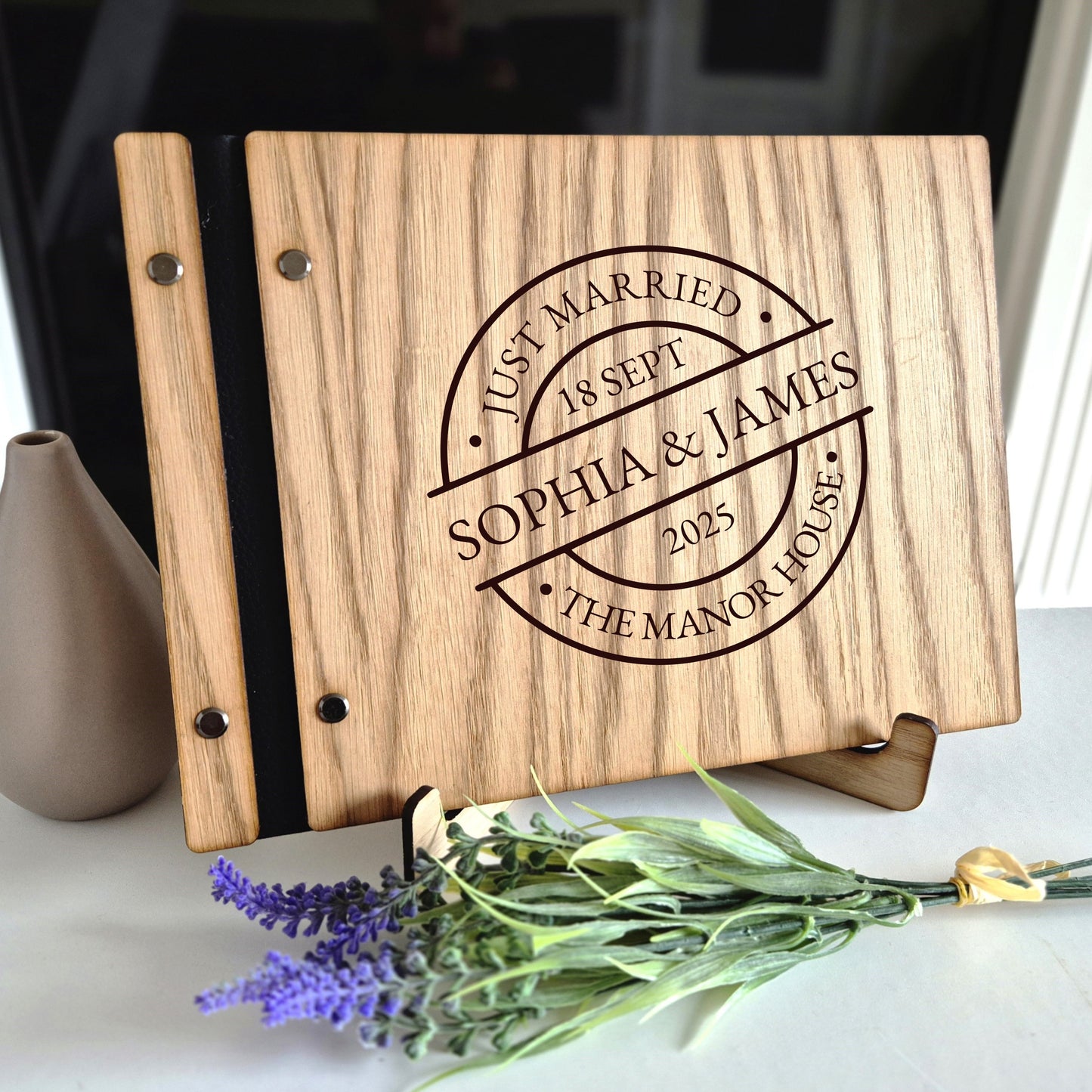 Image of a rustic style oak wedding book. The book is approximately 298mm x 216mm and includes high quality paper. The oak wedding book is laser engraved by laserengraveuk with a circular just married stamp design to the front. The design includes the married couple's names, date of wedding, and the venue.